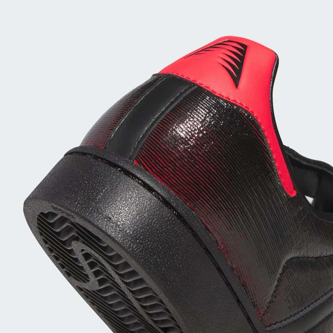 Detalle del talón de la adidas Superstar Halloween de Anthony Edwards, con la pieza roja, el cuero negro rayado y la suela negra