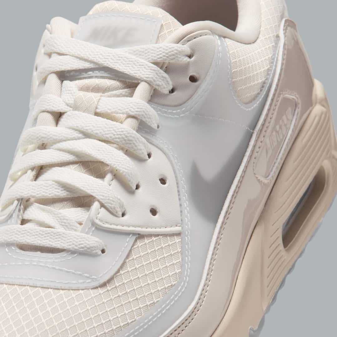 Primer plano del Nike Air Max 90 Light Orewood Brown con la malla clara, los cordones crema y las capas translúcidas sobre la capellada