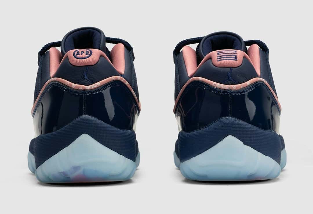 Talones de la APB x Air Jordan 11 Low Made for Locals: uno con el logo de APB y el otro con un gráfico de líneas bordados en azul sobre la pieza rosa del talón, con el Jumpman sobre el cuero azul