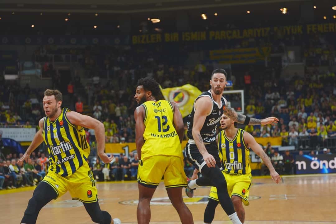 Foto de archivo: Luca Vildoza, con la camiseta negra del Partizan, ataca entre jugadores del Fenerbahçe, de amarillo y azul, en un partido de Euroliga