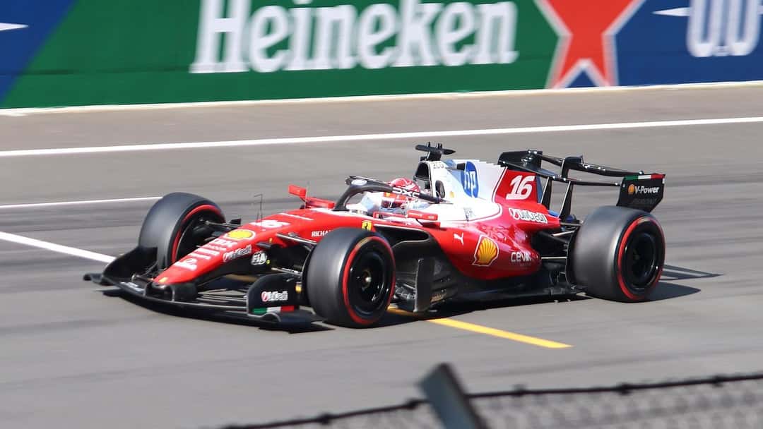 Foto de archivo: el Ferrari rojo y blanco número 16 de Charles Leclerc entra a una curva frente a un cartel publicitario verde en el Gran Premio de China 2026