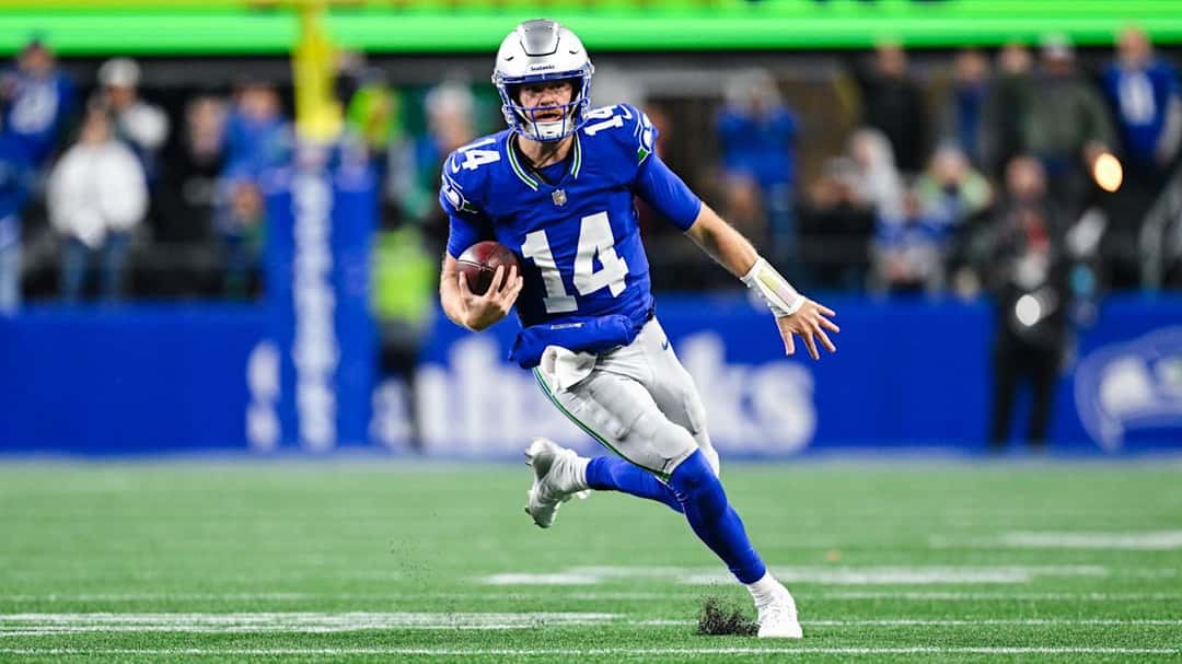 Sam Darnold, con la camiseta azul número 14 de los Seahawks, corre con la pelota en la mano durante el partido ante los Chiefs