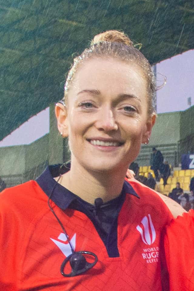 Foto de archivo: Hollie Davidson, con la camiseta roja de árbitra de World Rugby, sonríe a la cámara bajo la lluvia en un estadio