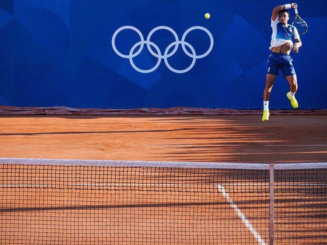 Foto de archivo: Arthur Fils salta para pegar un smash en una cancha de polvo de ladrillo con los anillos olímpicos de fondo, en París 2024