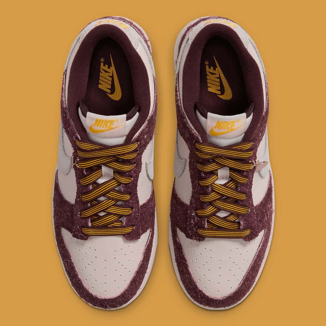Nike Dunk Low Basketball Charm vista desde arriba, con los cordones bordó y dorado, la lengüeta con el logo dorado y la base crema