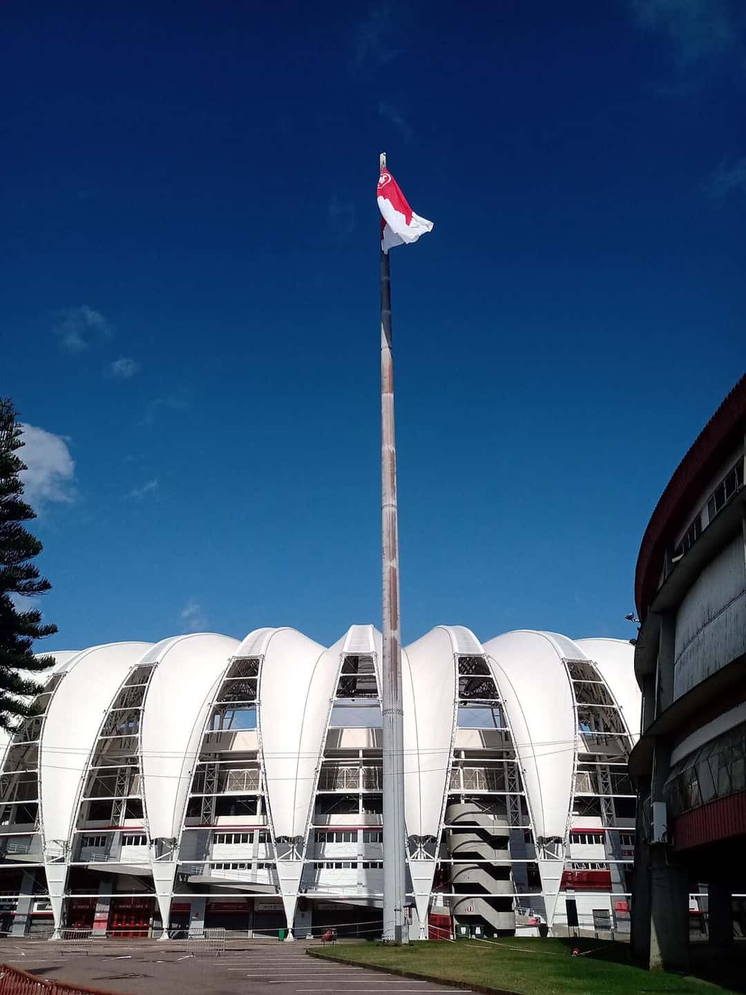 La bandera roja y blanca del Internacional flamea en lo alto de un mástil frente al estadio Beira-Rio; foto de archivo de 2021 (foto: Hedestad, Wikimedia Commons, licencia CC BY-SA 4.0)
