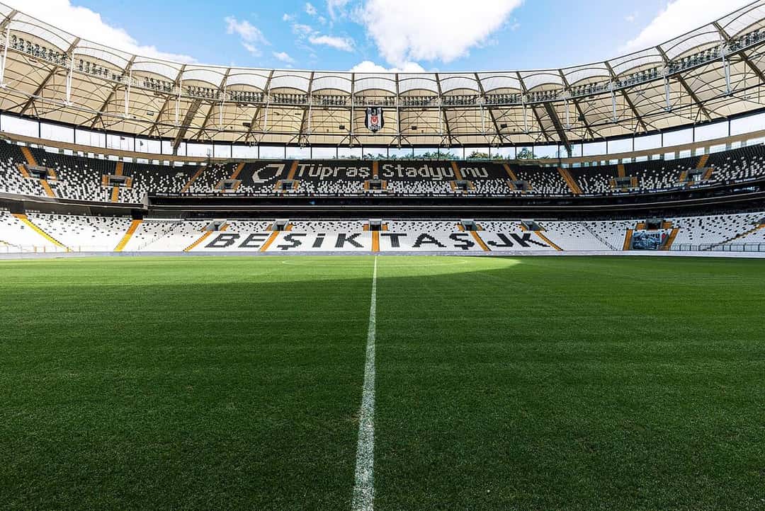 La cancha y las tribunas blancas y negras del Tüpraş Stadyumu, el estadio del Beşiktaş, con el nombre del club escrito en las butacas; foto de archivo de octubre de 2023 (foto: Beşiktaş JK, Wikimedia Commons, licencia CC BY 2.0)