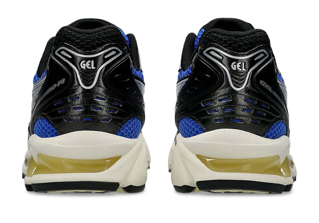 Talones del par de ASICS GEL-Kayano 14 Illusion Blue Pure Silver sobre fondo blanco, con la pieza negra con el logo GEL en plateado, la malla azul y la mediasuela crema con detalles amarillentos