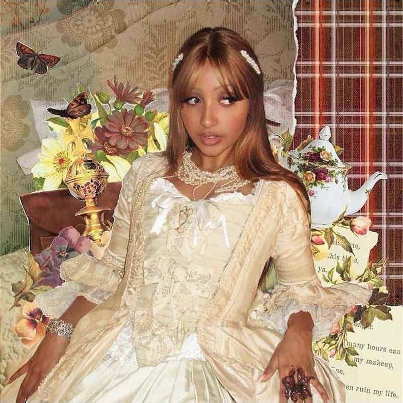 Portada del single «Tonight», de PinkPantheress: la cantante, con vestido de encaje color crema y moños en el pelo, sentada entre flores, mariposas y una tetera