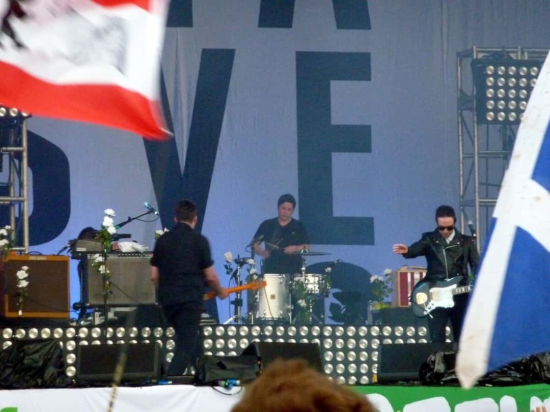 Glasvegas toca en el escenario de un festival en junio de 2009, con banderas del público en primer plano (foto de archivo). Foto: wonker, CC BY 2.0, vía Wikimedia Commons
