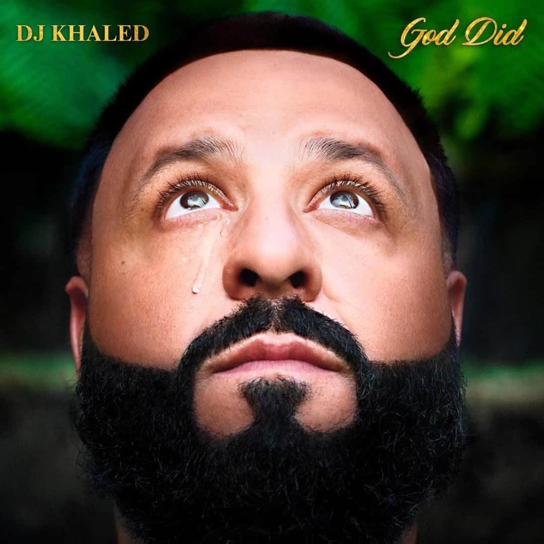 Portada de «GOD DID», de DJ Khaled: el productor mira hacia arriba con una lágrima en la mejilla, sobre un fondo verde de hojas