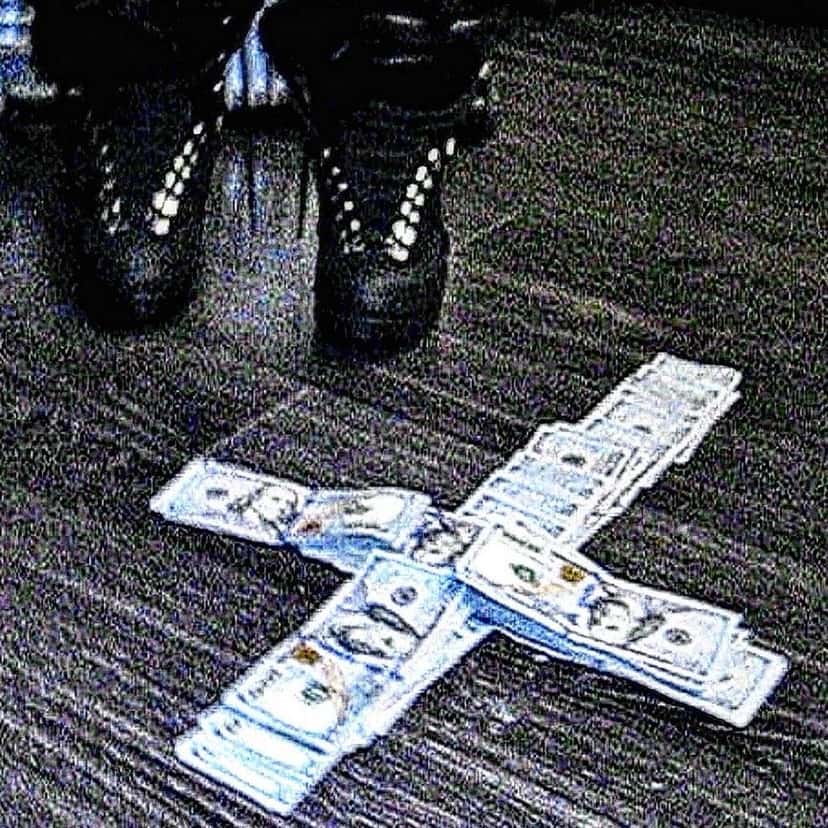Portada del single «catastrophe», de Ken Carson: billetes apilados en forma de cruz sobre una alfombra oscura, junto a un par de botas negras