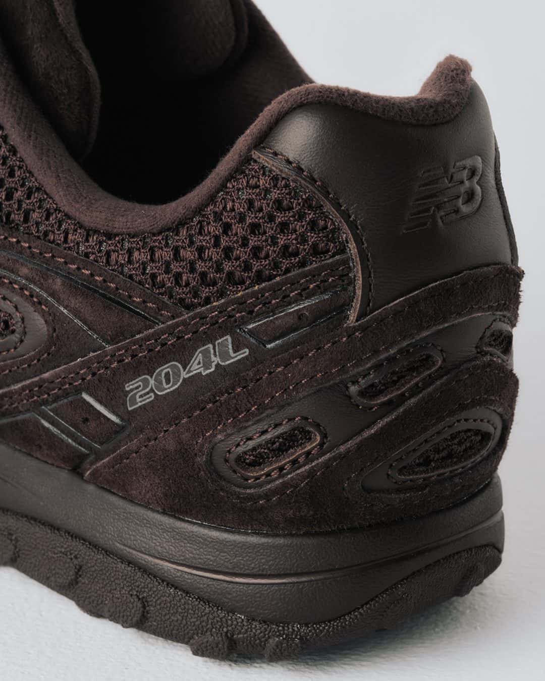 Detalle del talón de la BILLY'S x New Balance 204L, con el logo 204L y la malla marrón oscura