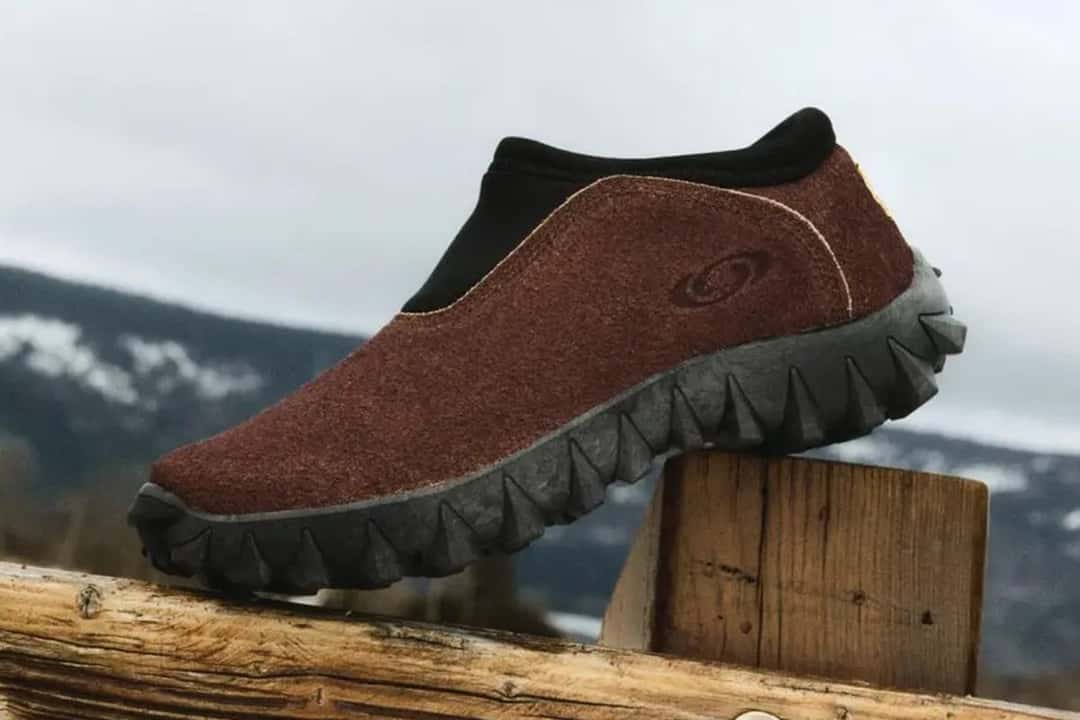 Salomon Snowclog OG del Expedition Pack en gamuza marrón con suela negra de tacos, sobre un poste de madera