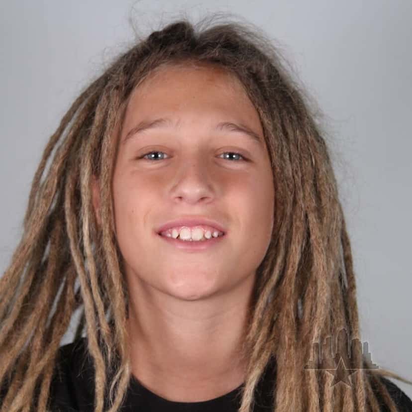 Retrato oficial de Zion Furegato, con rastas largas y remera negra, sobre fondo gris, del registro del Tampa Am 2026