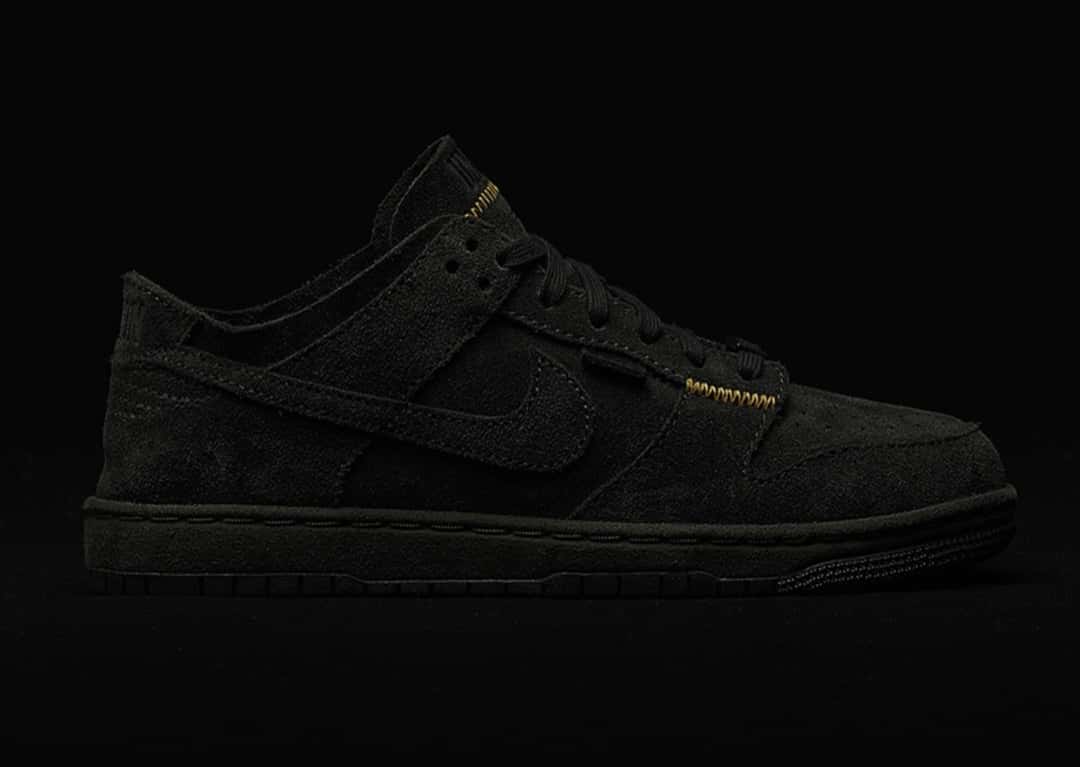 Union x Nike Dunk Low Natural Selection Eclipse, casi negra, con las costuras doradas en el lateral