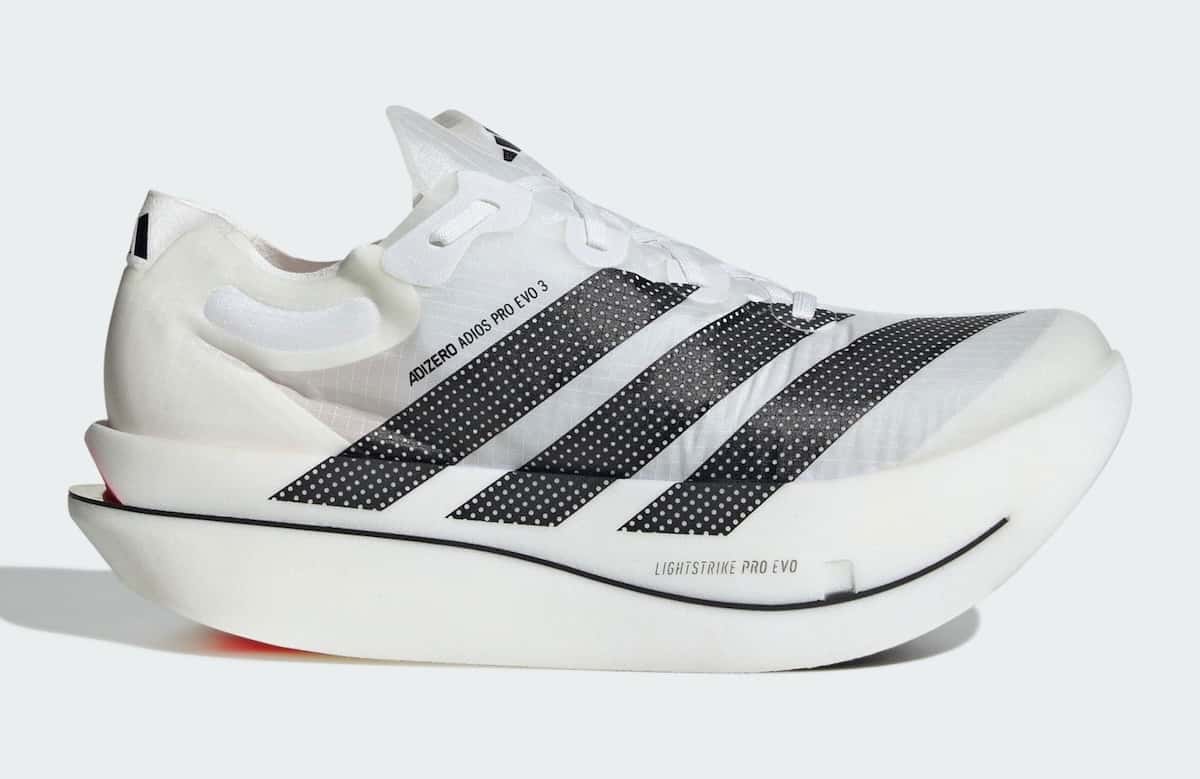 adidas Adizero Adios Pro Evo 3 de perfil sobre fondo gris claro: upper blanco semitransparente con tres tiras negras perforadas, mediasuela blanca muy alta y curva con una línea negra y un toque rojo en el talón