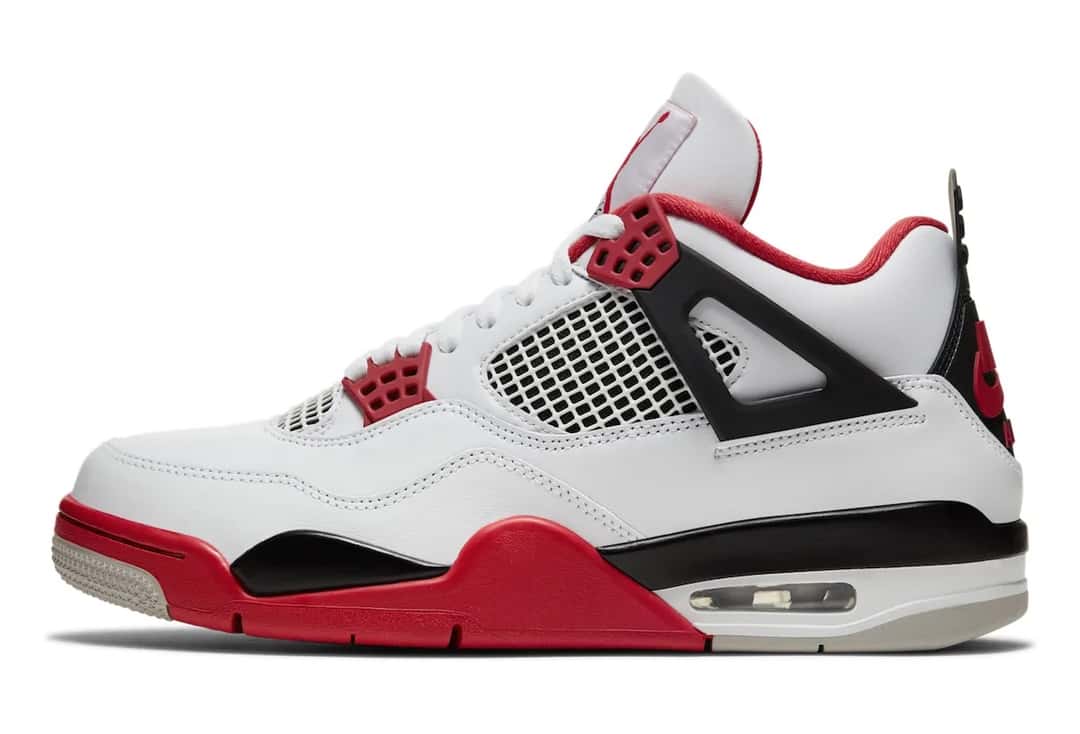 Foto de archivo: Air Jordan 4 Fire Red de 2020 de perfil sobre fondo blanco, con upper de cuero blanco, malla blanca con fondo negro, ojales rojos, ala con marco negro, forro rojo, mediasuela roja con un sector negro y unidad Air visible en el talón