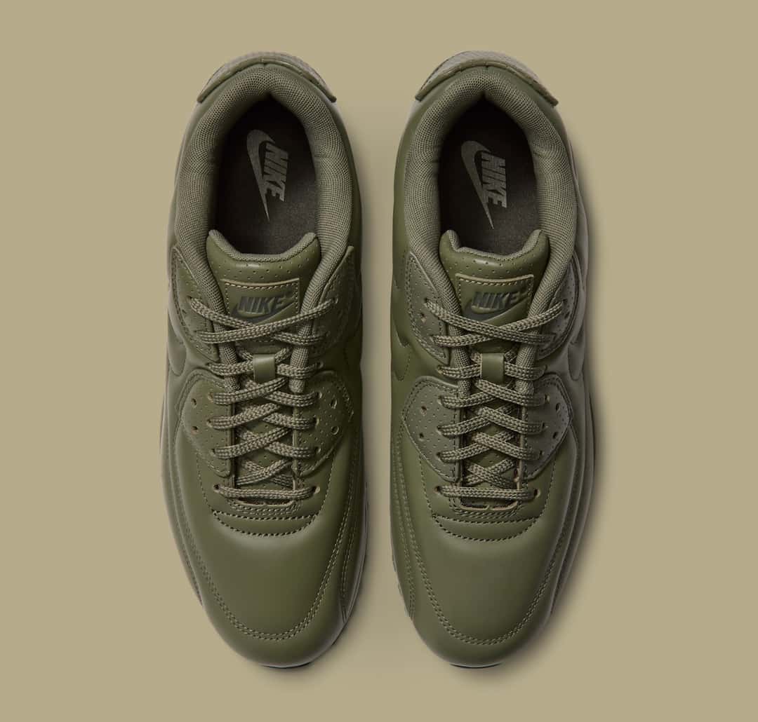 Vista desde arriba del par de Nike Air Max 90 SP Medium Olive, con los ojales de cuero perforado y el logo Nike en la lengüeta