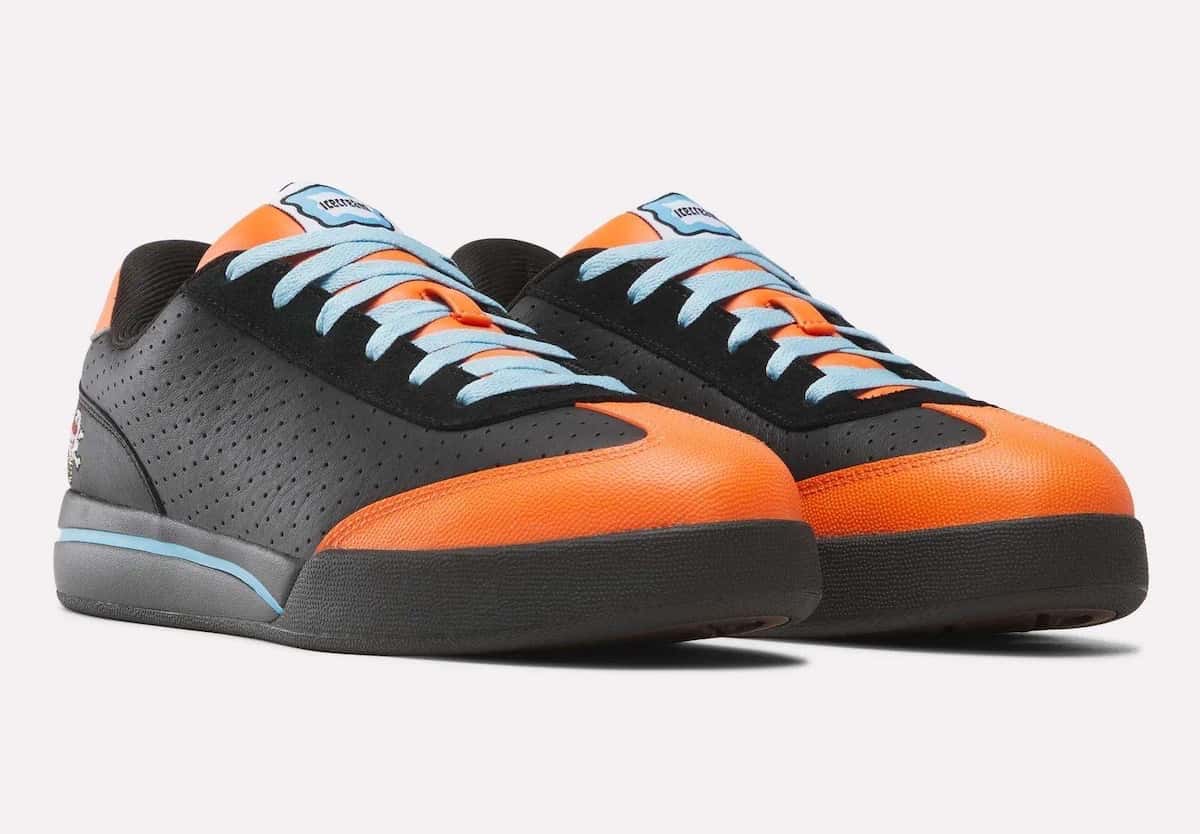 Par del BBC ICECREAM x Reebok Board Flip Pumpkin en diagonal sobre fondo gris claro: cuero negro perforado, puntera y talón naranjas, cordones celestes, el helado bordado en el costado y suela negra con una línea celeste