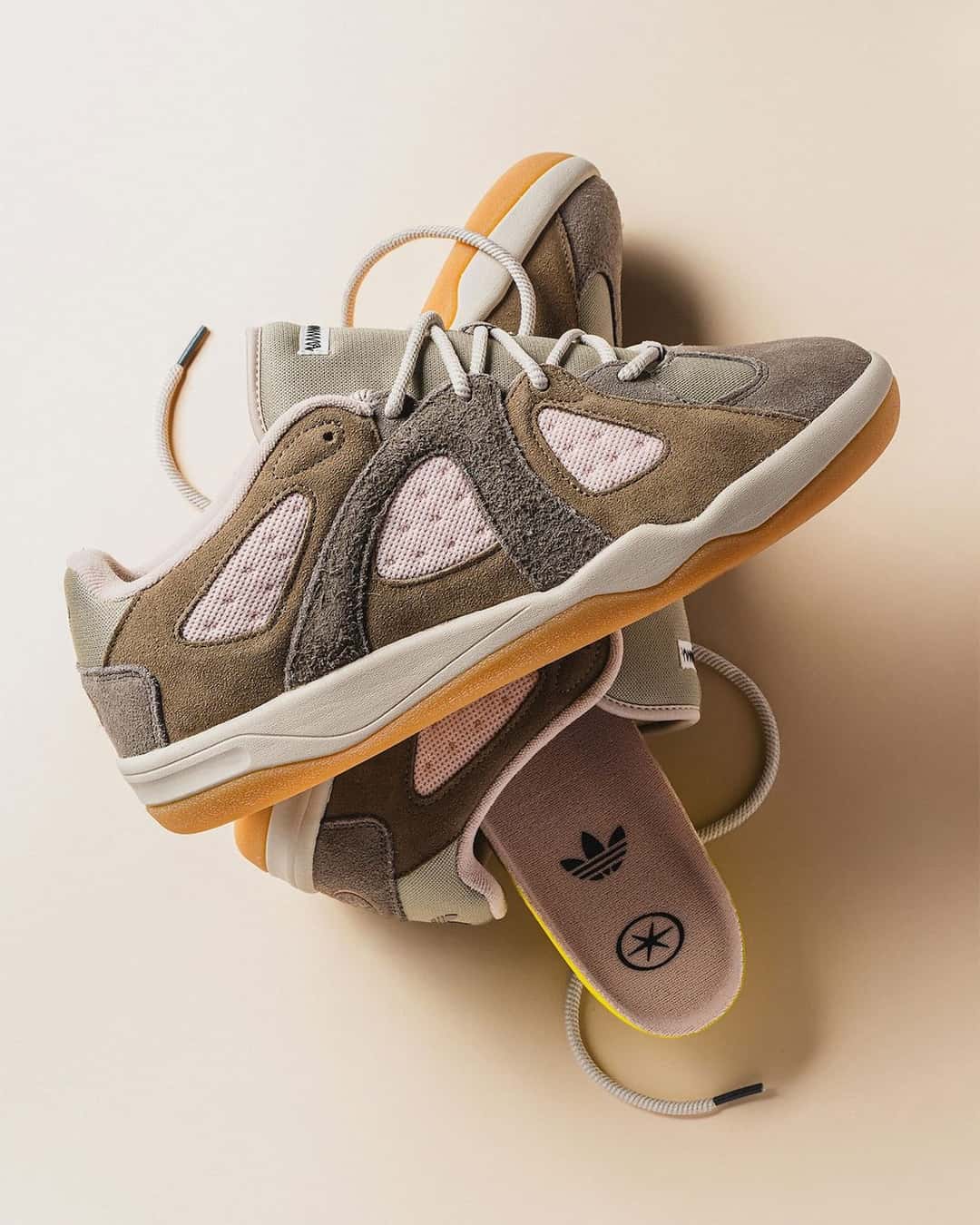 adidas BadBo 1.1 Simple Brown sobre fondo crema, con la gamuza marrón, los huecos rosa pálido, la suela de goma color miel y la plantilla a la vista