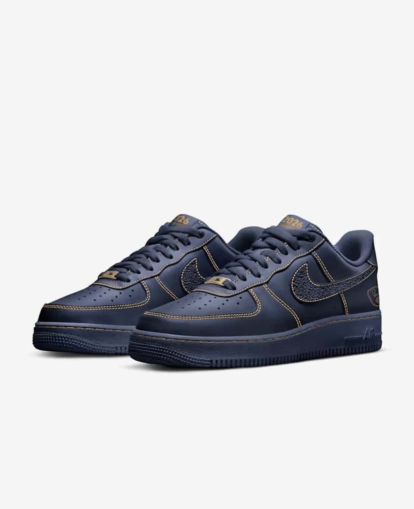 Par de la Nike Air Force 1 Low Milwaukee Brewers en vista de tres cuartos, en cuero azul marino con costuras doradas y el Swoosh texturado