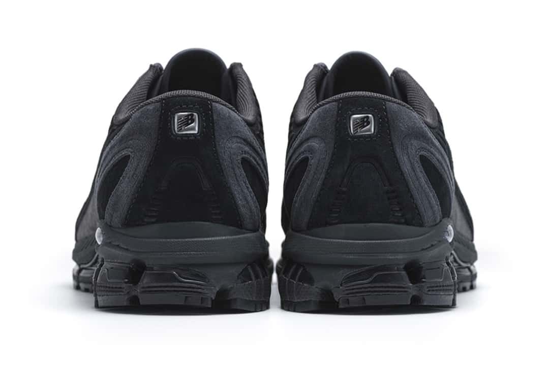 Talones de la COMME des GARÇONS HOMME x New Balance 1890A negra, con la placa metálica y la suela gris