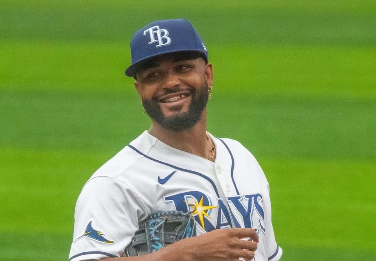 Foto de archivo: Junior Caminero sonríe en el campo con la camiseta blanca de los Tampa Bay Rays, la gorra azul con las letras TB y el guante en la mano