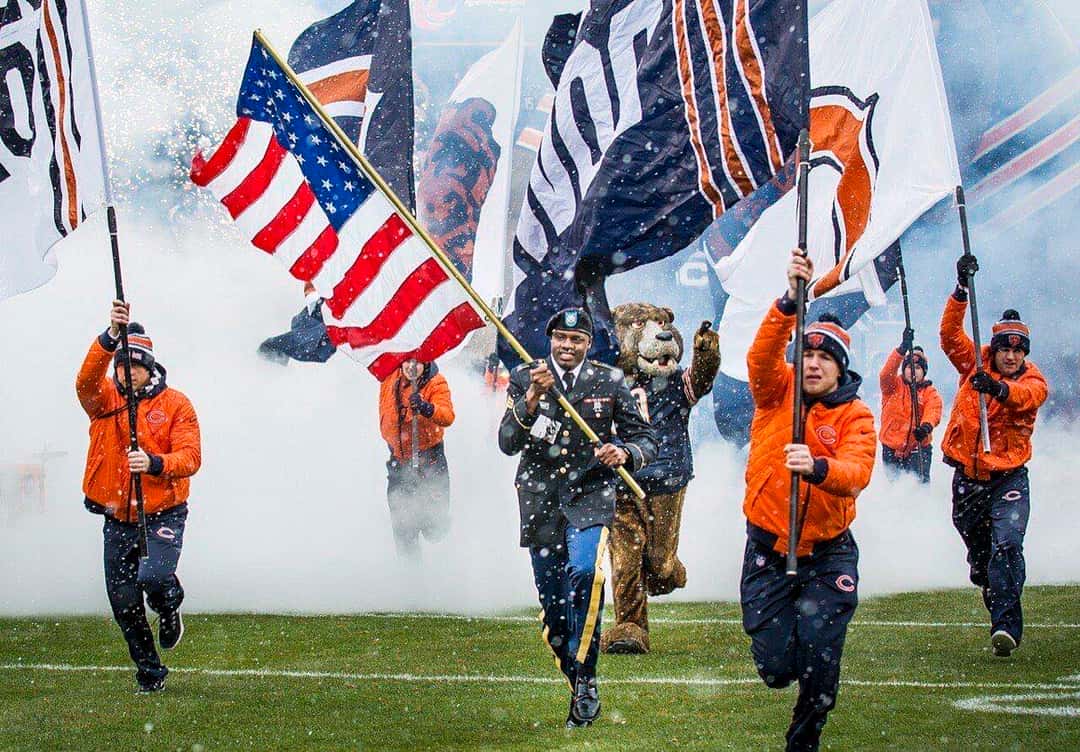 Foto de archivo: abanderados de los Bears, con camperas naranjas, salen corriendo a la cancha del Soldier Field entre humo y nieve
