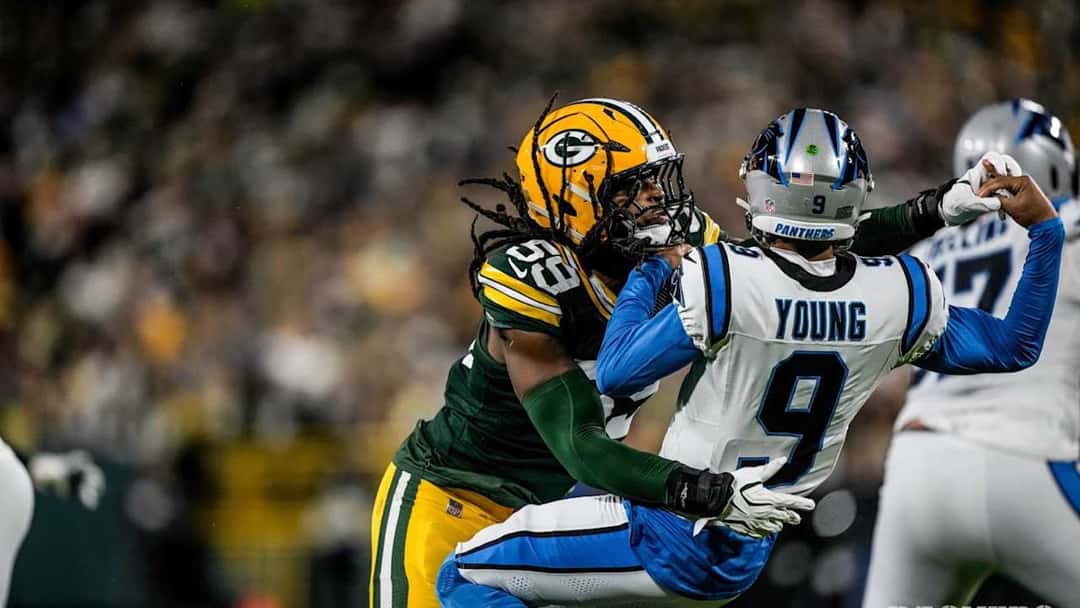 Un defensor de los Packers, de verde, derriba a Bryce Young, mariscal de campo de los Panthers, con la camiseta blanca número 9