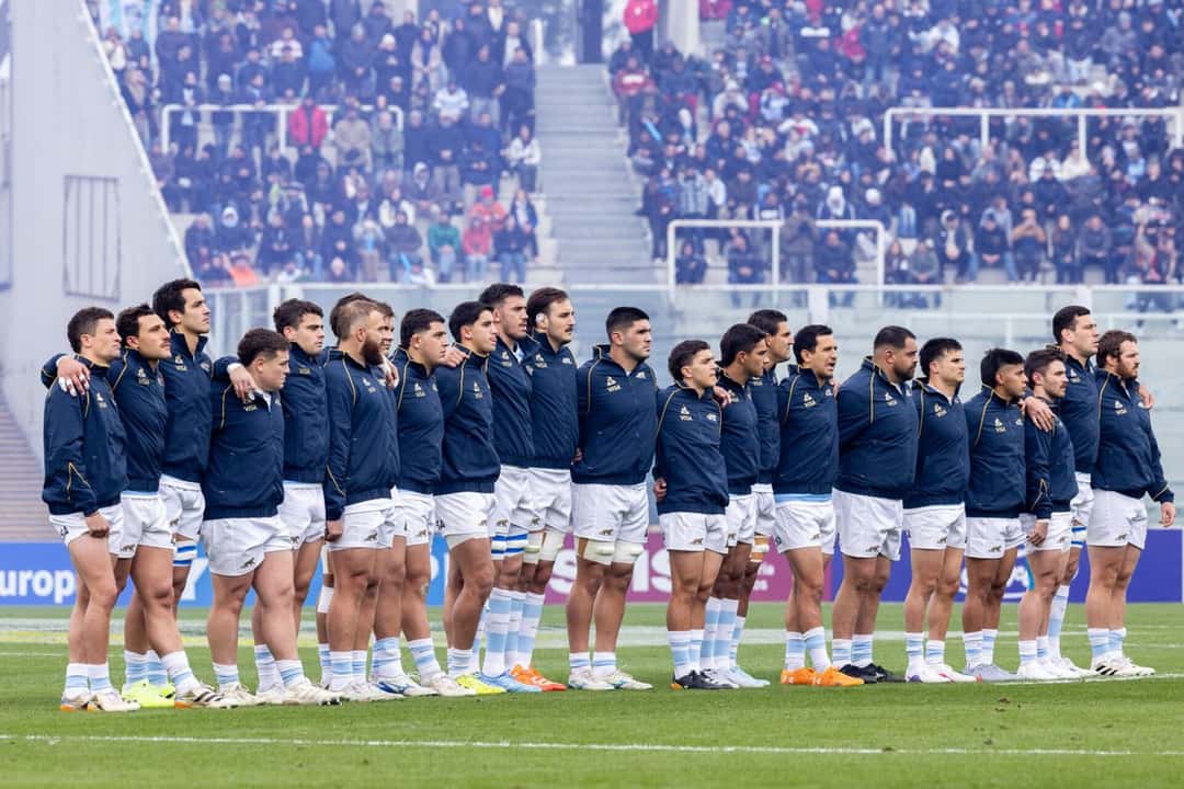 Foto de archivo: los jugadores de Los Pumas, con campera azul oscuro, abrazados en fila durante el himno antes de un test ante Escocia en Córdoba