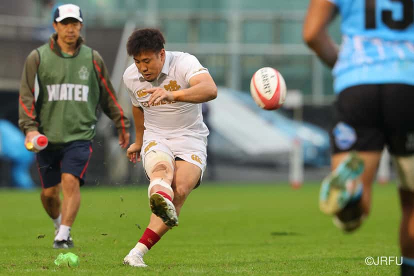 Un jugador de Japón, de blanco, patea la pelota en el estadio Chichibunomiya durante el test ante Fiyi