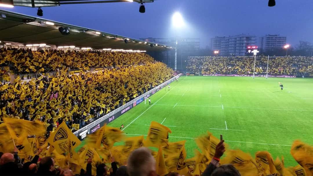 Foto de archivo: la hinchada de La Rochelle agita banderas amarillas y negras en la tribuna del Stade Marcel-Deflandre en una noche de Top 14