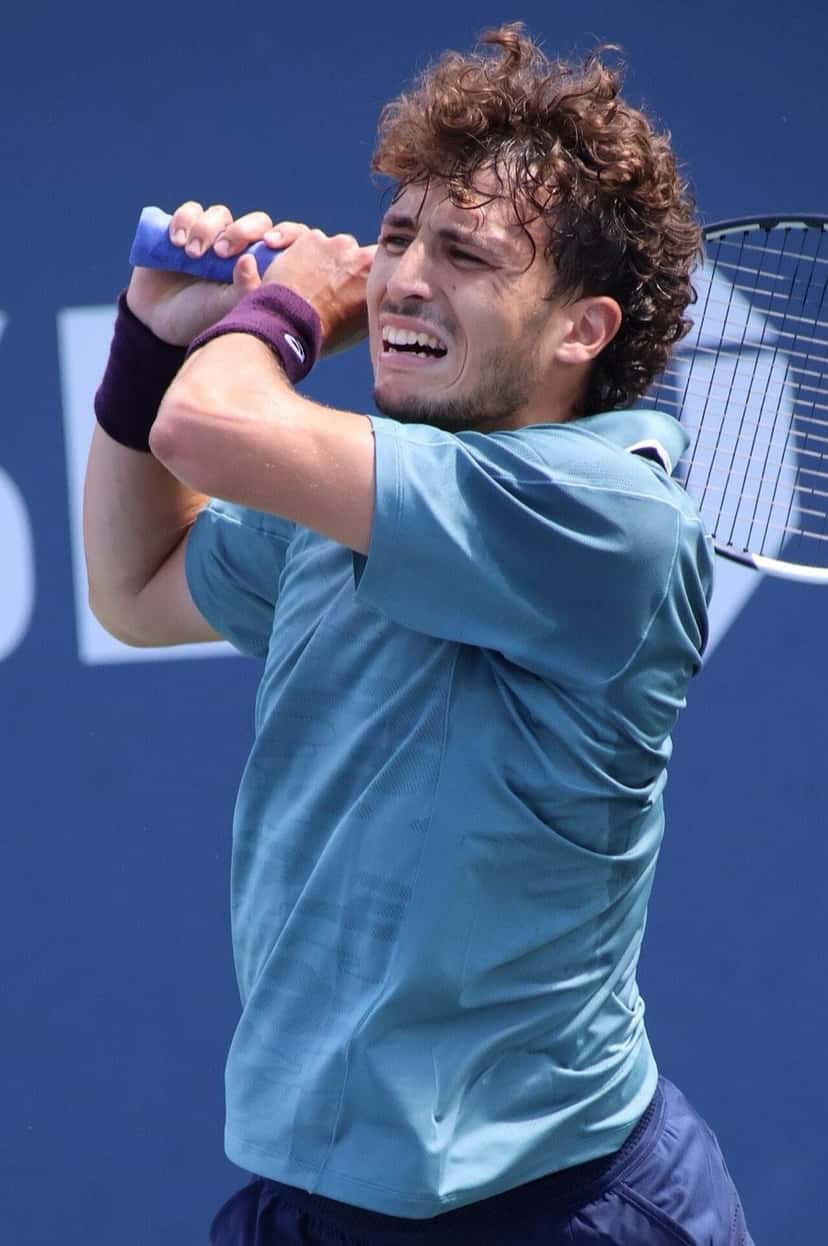 Foto de archivo: Clément Chidekh, con remera celeste y muñequera violeta, termina un golpe de derecha con las dos manos arriba