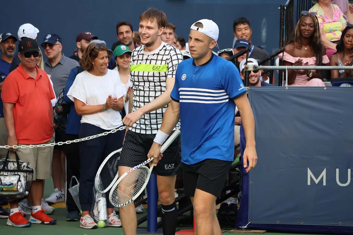 Foto de archivo: Tallon Griekspoor, de remera azul y gorra blanca, entra a la cancha junto a Alexander Bublik en el torneo de Washington 2023