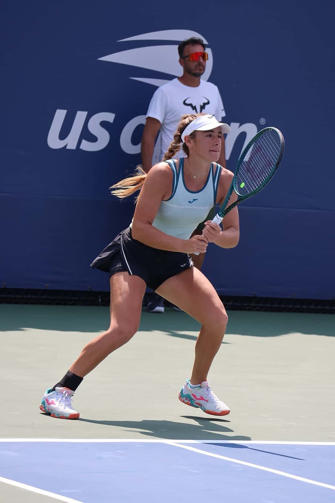 Foto de archivo: Solana Sierra, con visera blanca y musculosa celeste, espera la devolución en posición de recepción en el US Open 2024