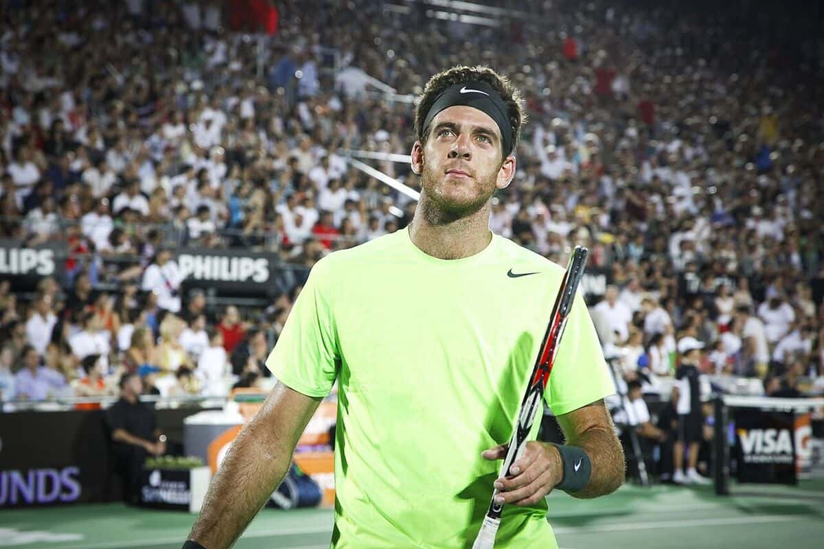 Foto de archivo: Juan Martín del Potro, con remera verde fluo y vincha negra, mira hacia la tribuna con la raqueta en la mano durante una exhibición en Tigre en 2012