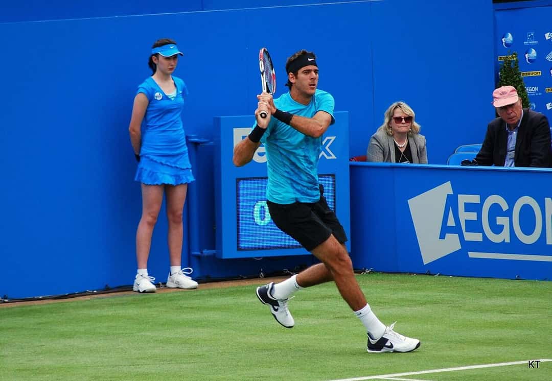 Foto de archivo: Juan Martín del Potro, con remera celeste y short negro, corre hacia la pelota en una cancha de césped del torneo de Queen's, en 2011