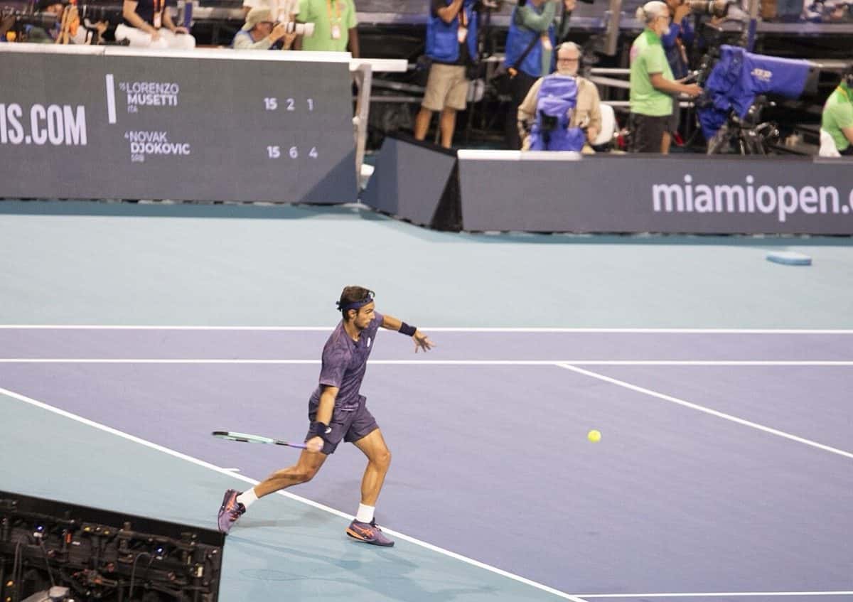 Foto de archivo: Lorenzo Musetti, de camiseta oscura, corre hacia la pelota en una cancha dura azul del Abierto de Miami 2025