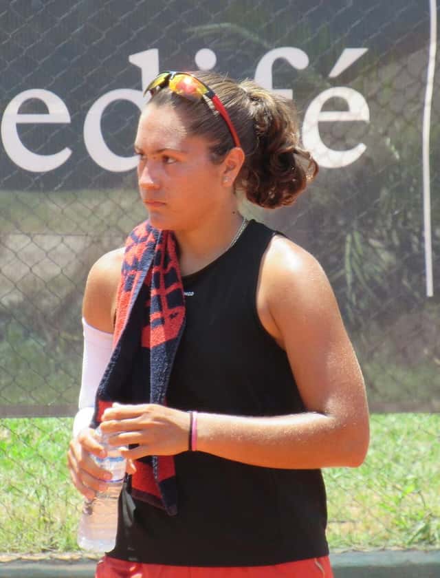 Foto de archivo: Luisina Giovannini, con musculosa negra, anteojos de sol sobre la cabeza y una toalla al hombro, en una cancha de tenis