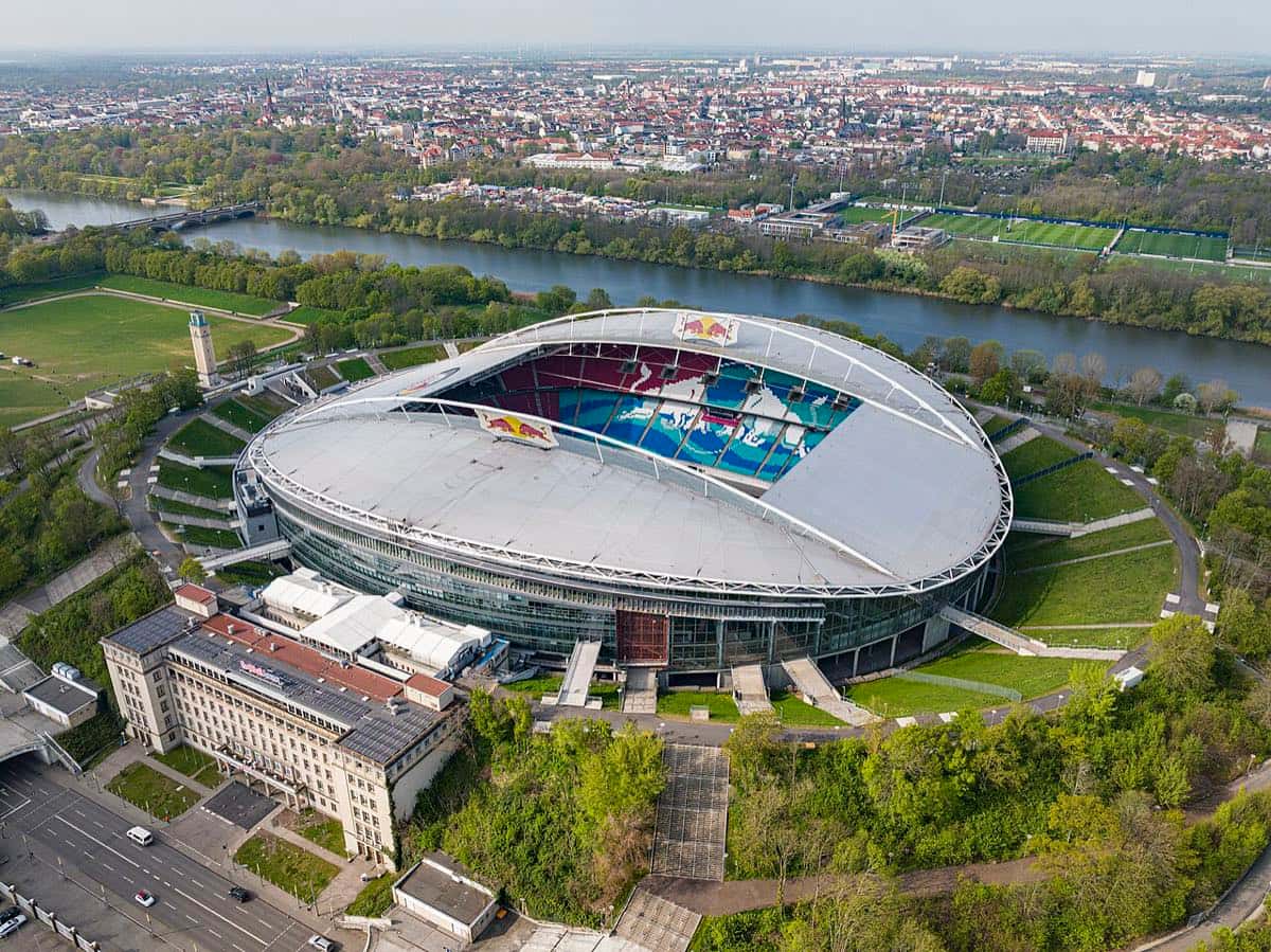 Vista aérea de la Red Bull Arena de Leipzig, con el techo blanco, las tribunas y el río de fondo; foto de archivo de abril de 2022 (foto: Arne Müseler, Wikimedia Commons, licencia CC BY-SA 3.0 DE)