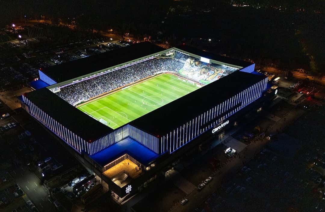 Vista aérea nocturna del Claro Arena, el estadio de la Universidad Católica en San Carlos de Apoquindo, iluminado y con las tribunas llenas el día de su inauguración; foto de archivo de agosto de 2025 (foto: Beto Comunicaciones, Wikimedia Commons, licencia CC BY-SA 4.0)