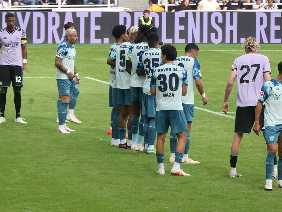 Jugadores del Bayer Leverkusen, con la camiseta celeste de visitante, reunidos en la cancha durante un amistoso ante el Newcastle; foto de archivo de agosto de 2026 (foto: Ardfern, Wikimedia Commons, licencia CC BY-SA 4.0)