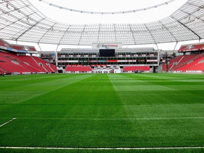 El interior del BayArena, el estadio del Bayer Leverkusen, con el césped verde y las tribunas rojas y blancas bajo el techo; foto de archivo de 2015 (foto: Partonez, Wikimedia Commons, licencia CC BY-SA 4.0)