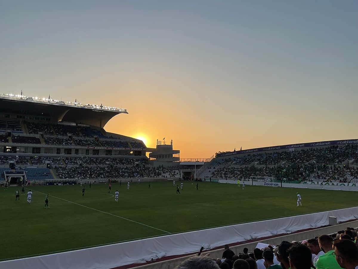 El estadio GSP de Nicosia, la cancha del Omonia, durante un partido al atardecer, con el sol cayendo detrás de la tribuna; foto de archivo de 2021 (foto: Vincenzo.togni, Wikimedia Commons, licencia CC BY-SA 4.0)