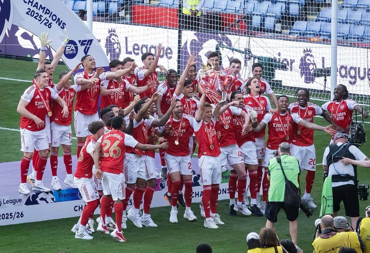 Los jugadores del Arsenal, con la camiseta roja, saltan y festejan con el trofeo de campeones de la Premier League 2025-26 frente a la tribuna; foto de archivo de mayo de 2026 (foto: Chensiyuan, Wikimedia Commons, licencia CC BY-SA 4.0)