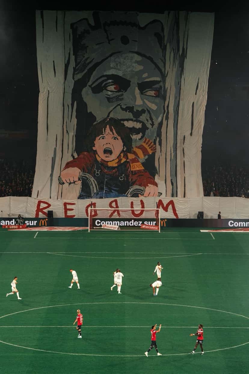 La tribuna de Lille despliega un gran telón con un dibujo antes del clásico, mientras los jugadores de los dos equipos esperan en el campo del Pierre-Mauroy, el viernes 30 de octubre (foto: LOSC)