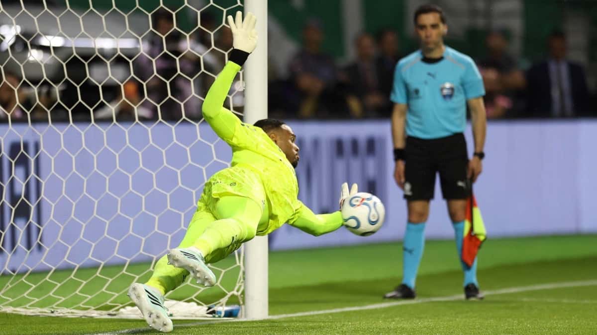 Carlos Miguel, arquero de Palmeiras, vestido de verde flúor, se estira contra el palo y ataja un penal en la definición con Fluminense en el Nubank Parque (foto: Cesar Greco / Palmeiras)