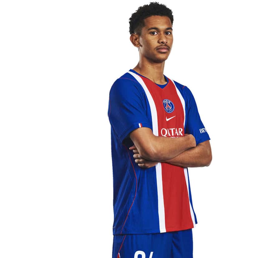 Senny Mayulu, con los brazos cruzados y la camiseta azul y roja del PSG de la temporada 2026-27, en la foto oficial del plantel (foto: Paris Saint-Germain)