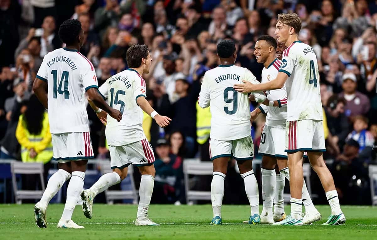 Jugadores del Real Madrid, con la camiseta blanca, festejan un gol ante el Sevilla en el Santiago Bernabéu; se ven Tchouaméni con el 14, Arda Güler con el 15 y Endrick con el 9 (foto: Real Madrid C.F.)